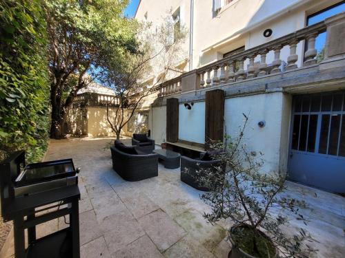 a courtyard with two couches and a building at Magnifique Appartement 8 personnes hyper centre in Montpellier