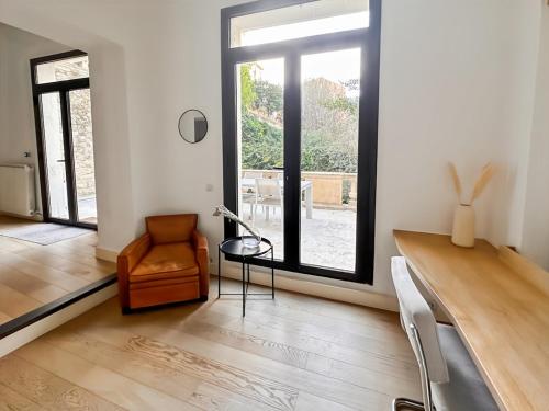 a living room with a chair and a glass table at Magnifique Appartement 8 personnes hyper centre in Montpellier