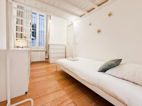 a white bedroom with a large bed and a window at Magnifique Appartement 8 personnes hyper centre in Montpellier