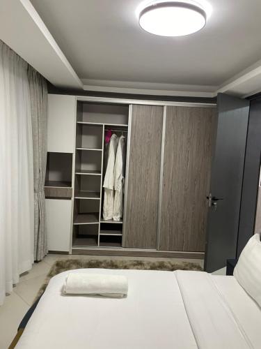 a bedroom with a bed and a closet at Infinity Villas 1 Superking bed Studio Apartment free parking , WiFi , 24 hr security in Entebbe