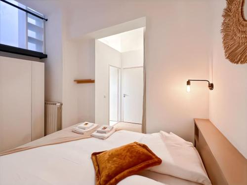 a white bedroom with a bed and a window at Magnifique Appartement 8 personnes hyper centre in Montpellier