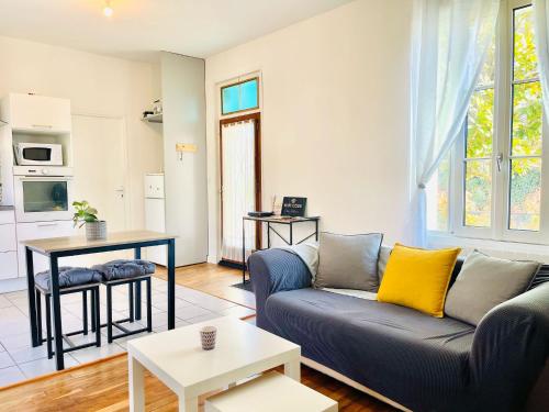 ein Wohnzimmer mit Sofa und Tisch in der Unterkunft Chez Arthur -Séjour en Sologne in La Ferté-Saint-Aubin