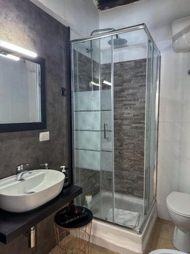 a bathroom with a glass shower and a sink at La Nicchia in Cagliari