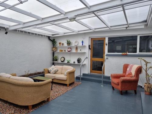 a living room with couches and chairs under a roof at NITB Approved Bungalow in Castlerock in Castlerock