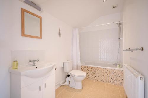 a bathroom with a sink and a toilet and a bath tub at The Old Dairy in Cookley