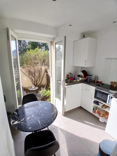 - une cuisine avec une table, une table et des chaises dans l'établissement Appartement F1 location proche mer, à La Garde