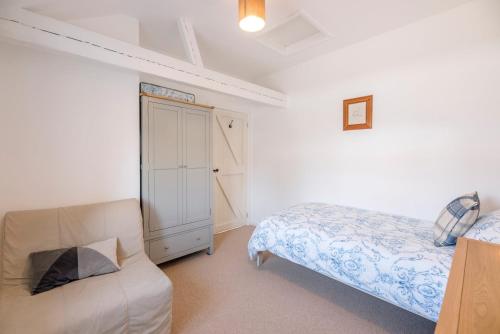 a small bedroom with a bed and a couch at The Old Dairy in Cookley