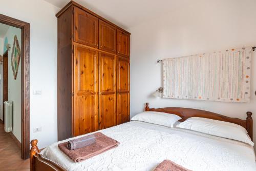 a bedroom with a bed and a wooden cabinet at Su Cilleri e Silbiu in Baunei