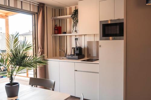 a kitchen with white cabinets and a table at Domvs Glamp in Baveno