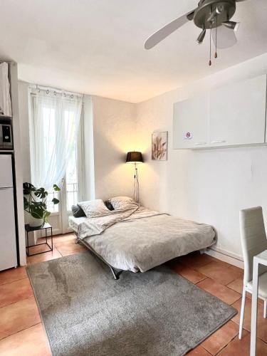 une chambre avec un lit et un ventilateur de plafond dans l'établissement Appartement à Nice Acropolis avec terrasse, à Nice