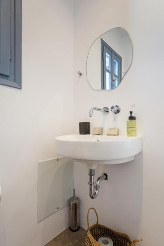 a bathroom with a sink and a mirror at Aitheras Luxury Suites in Protorgia