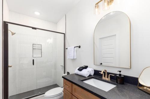 a bathroom with a shower and a sink and a mirror at Modern Comfort Near AU l Perfect for Families & Fans in Auburn