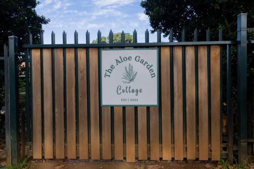 a gate with a sign on it with a fence at The Aloe Garden Cottage in Howick