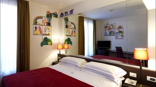 a bedroom with a large bed and a mirror at Phi Hotel Bologna in Bologna