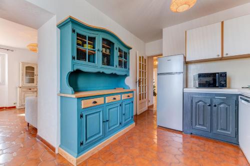 La cuisine est équipée de placards bleus et d'un réfrigérateur. dans l'établissement Havre de paix - Wifi, AC, parking, 4 pers, à Nice
