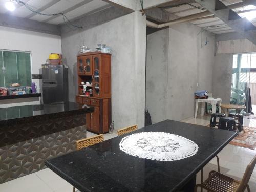 a kitchen with a table and a counter with a refrigerator at COP 30 Casa com 3 quartos sendo 1 suite 4 banheiros sala cozinha e garagem in Ananindeua