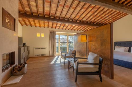 a bedroom with a bed and a table and chairs at Mastrojanni Relais in Montalcino