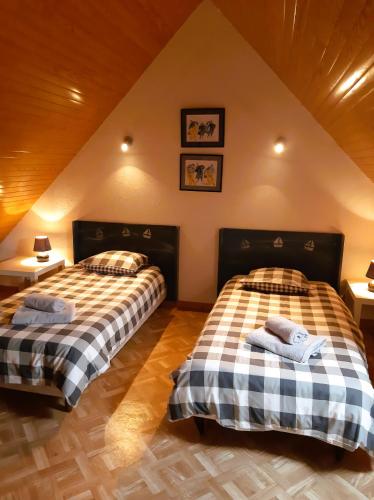 - 2 lits dans une chambre mansardée dans l'établissement Rigadell, à Penmarcʼh