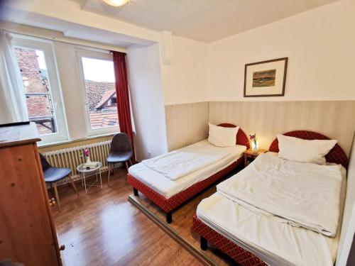 a hotel room with two beds and a window at Alte Rathausschänke - Hotel Garni in Hannoversch Münden