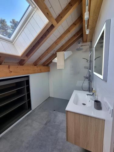 une salle de bain avec un lavabo et une fenêtre dans l'établissement Le Jura entre Annecy et Genève, à Feigères