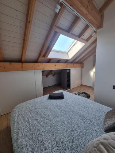 une chambre avec un grand lit dans un grenier dans l'établissement Le Jura entre Annecy et Genève, à Feigères
