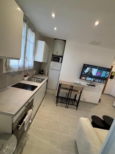 - une cuisine avec des appareils blancs, une table et des chaises dans l'établissement Charmant appartement rénové en plein centre ville, à Draveil