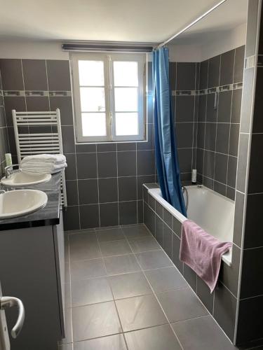une salle de bain avec une baignoire et un lavabo dans l'établissement Maison des Cordeliers, à Bayeux