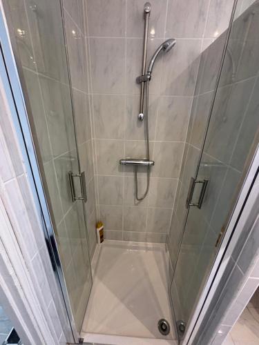 une cabine de douche avec une porte de douche en verre dans l'établissement Charmant appartement rénové en plein centre ville, à Draveil