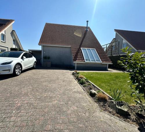 ein weißes Auto, das vor einem Haus parkt in der Unterkunft Ferienhaus im Villenpark Scharendijke in Scharendijke
