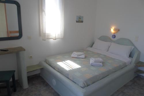 a bedroom with a bed with two towels on it at Aegean Sunset in Kionia