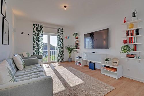 a living room with a couch and a tv at Sea Salt, Sagres Apartment in Sagres