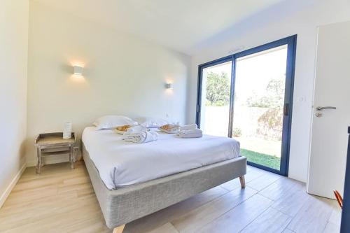 un lit dans une chambre avec une grande fenêtre dans l'établissement Chiron Reculeau - Piscine - Wifi, à Bois-de-Cené