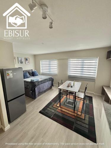 a bedroom with a bed and a table in a room at EBISUR Apart - Hoteles OROMPELLO in Concepción