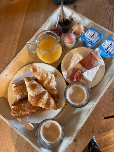 bandeja de comida con bollería y café en una mesa en Le Plantier 1, en Beaulieu-sur-Sonnette
