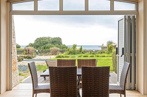 a dining room with a table and chairs on a patio at Pestana Alvor Praia Premium Beach & Golf Resort in Alvor