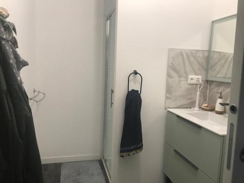 une salle de bain blanche avec un lavabo et un miroir dans l'établissement cozy house with heated pool maison avec piscine, à Savenay