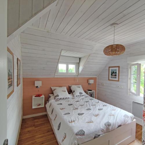 une chambre avec un grand lit dans un grenier dans l'établissement Appartement 2 chambres Bassin d'Arcachon front de mer, plage du Betey, à Andernos-les-Bains