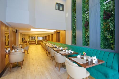 un ristorante con tavoli lunghi e sedie bianche di Downtown Sirkeci Hotel a Istanbul