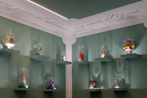 a display of glass lamps on shelves on a wall at Phi Hotel Bologna in Bologna