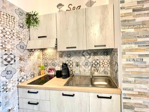Una cocina con gabinetes blancos y un fregadero. en TAMARICI BEACH HOUSE - Anzio, en Anzio