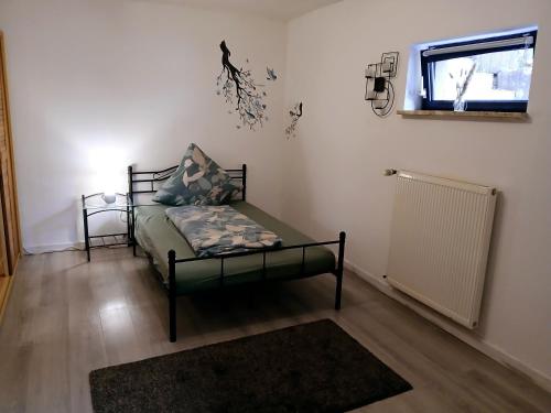 a small room with a bed and a window at Zum Symposion in Namborn