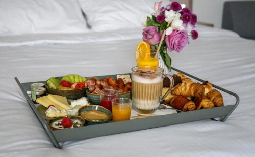 a tray of breakfast foods and drinks on a bed at Novotel Paris Gare De Lyon in Paris