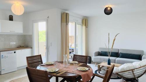 un salon avec une table, des chaises et un canapé dans l'établissement Appartement ELISA Calvi, à Calvi