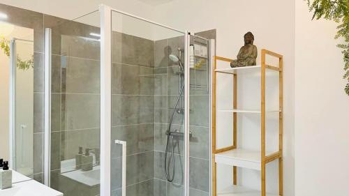 une salle de bain avec une douche avec une porte vitrée dans l'établissement Appartement ELISA Calvi, à Calvi