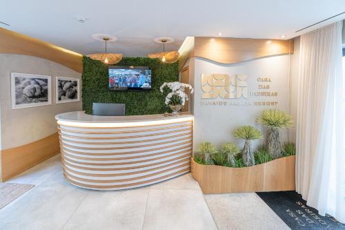 a lobby with a round reception counter with plants at Favaios Aldeia Resort - Casa das Padeiras in Favaios