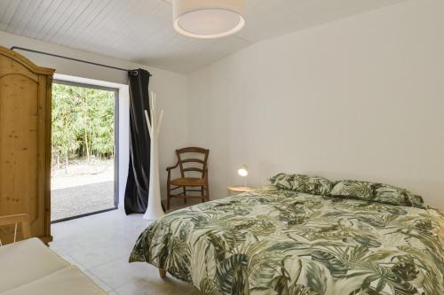 a bedroom with a bed and a chair and a window at Villa Cali - Air-conditioned, Pool, Heart Village in Cabrières-dʼAvignon