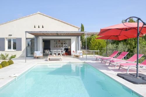 - une piscine avec des chaises et un parasol rouge dans l'établissement Villa Cali - Air-conditioned, Pool, Heart Village, à Cabrières-dʼAvignon