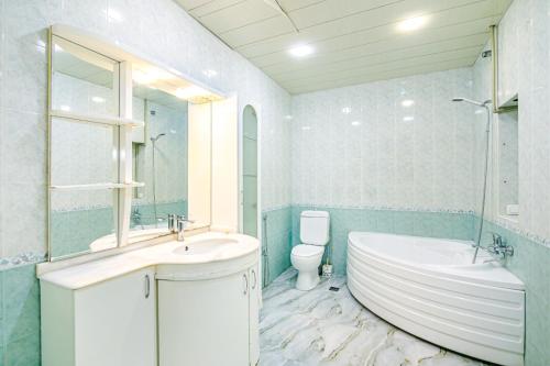 a bathroom with a tub and a sink and a toilet at Apartment AERİA in Baku