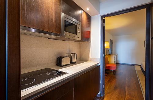 a kitchen with a stove and a microwave at Pestana Alvor Praia Premium Beach & Golf Resort in Alvor
