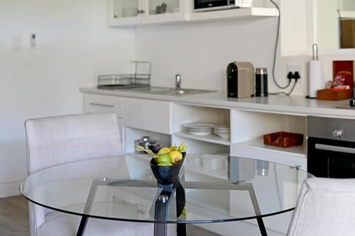 a glass table with a bowl of fruit on it in a kitchen at Fransvliet Guest House in Franschhoek